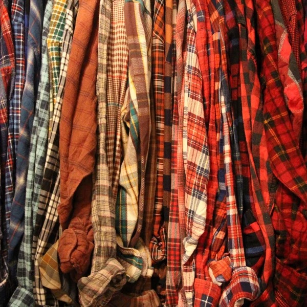 Rack of red and orange plaid flannel shirts.