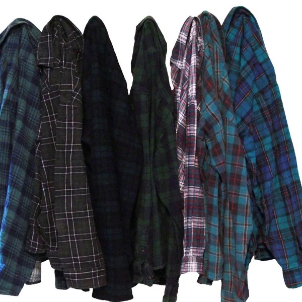 Row of oversized distressed flannel shirts in dark plaids.